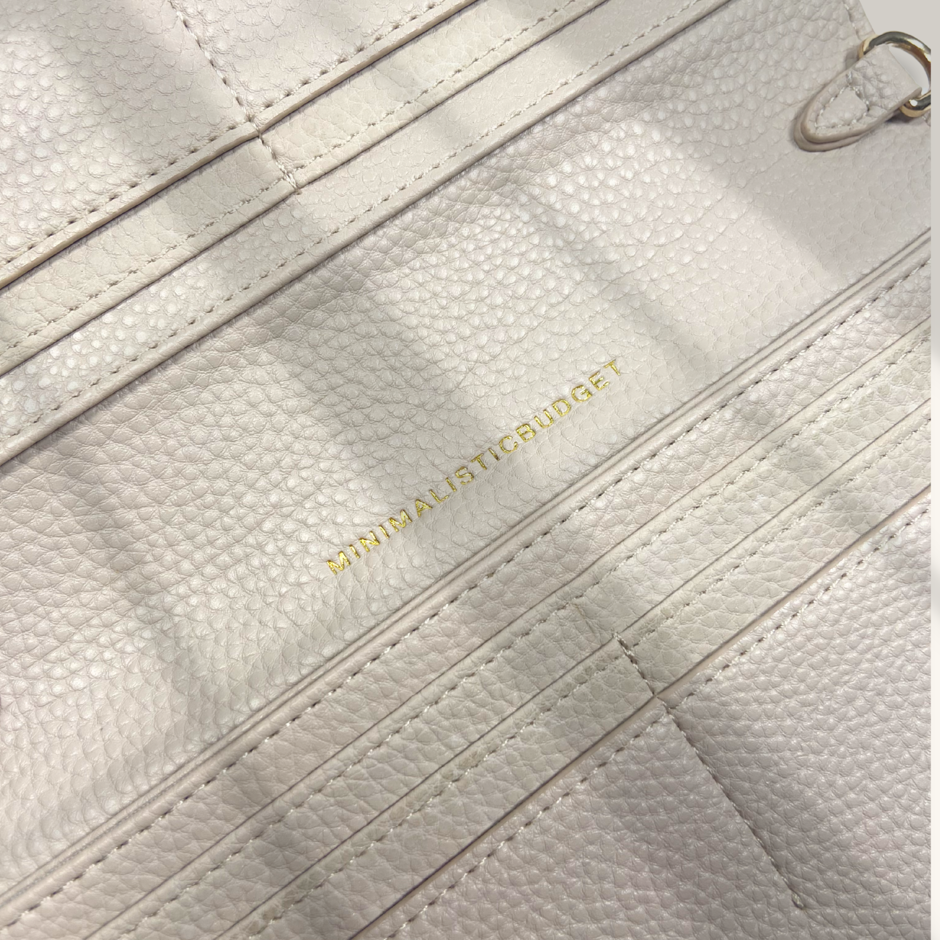 Close-up of a textured beige handbag with 'Minimalistic Budget' branding.