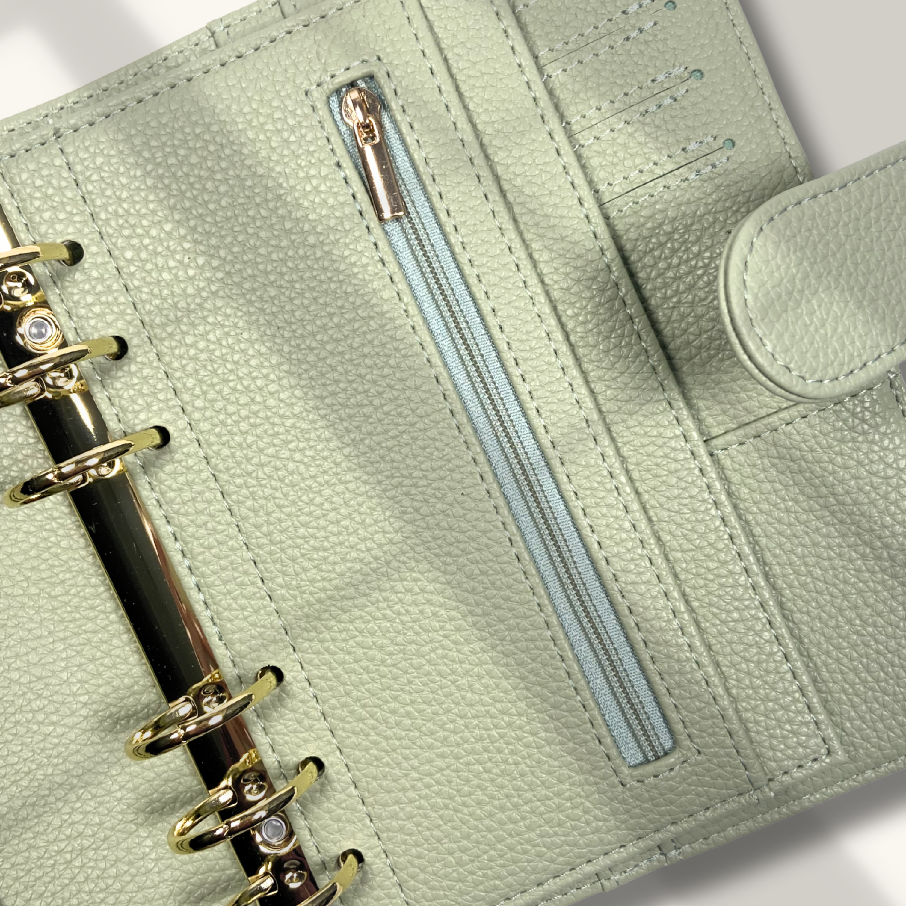 Light green planner with a zipper pocket on a white background