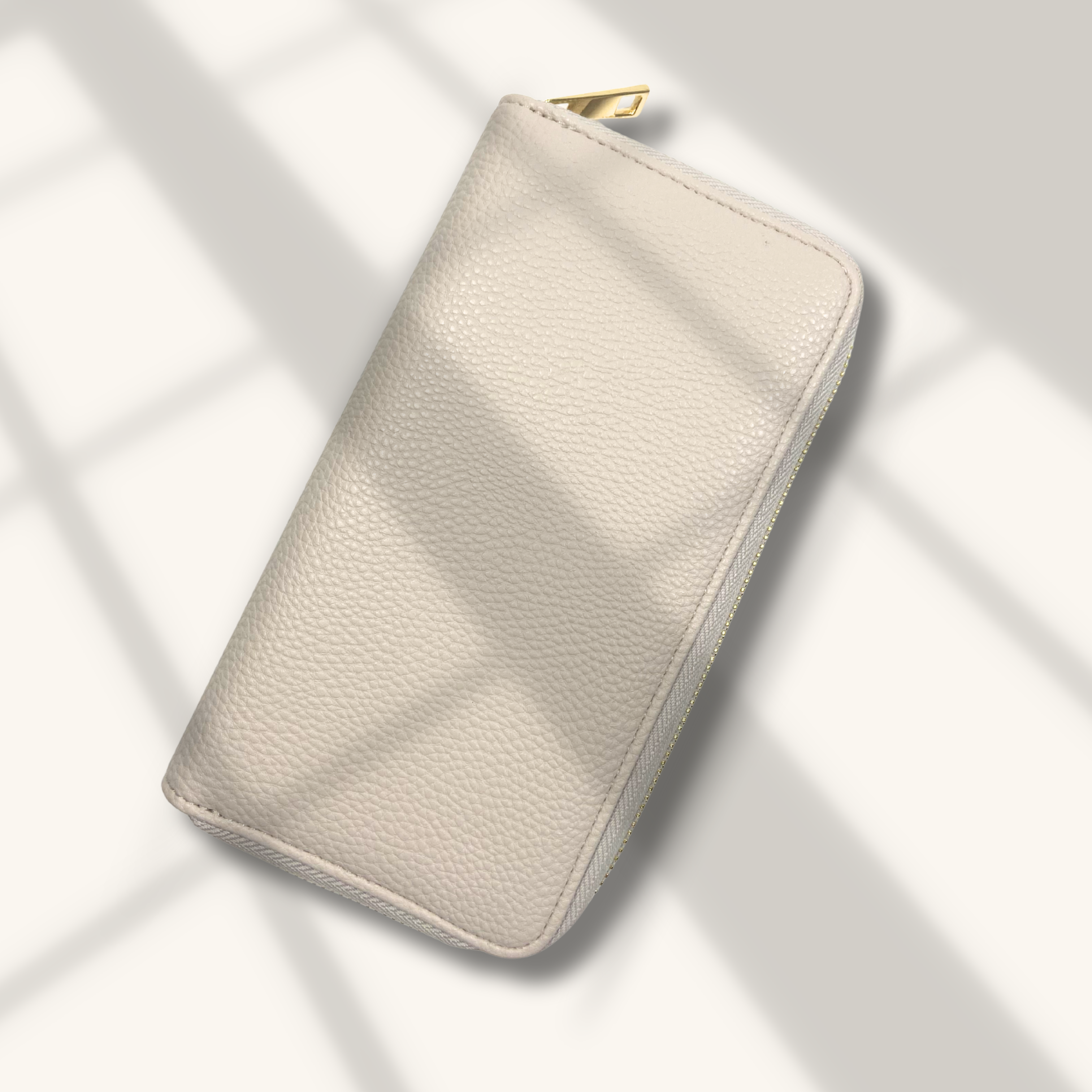 Beige leather wallet on a light gray background