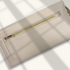 Beige wallet with gold zipper on a light background