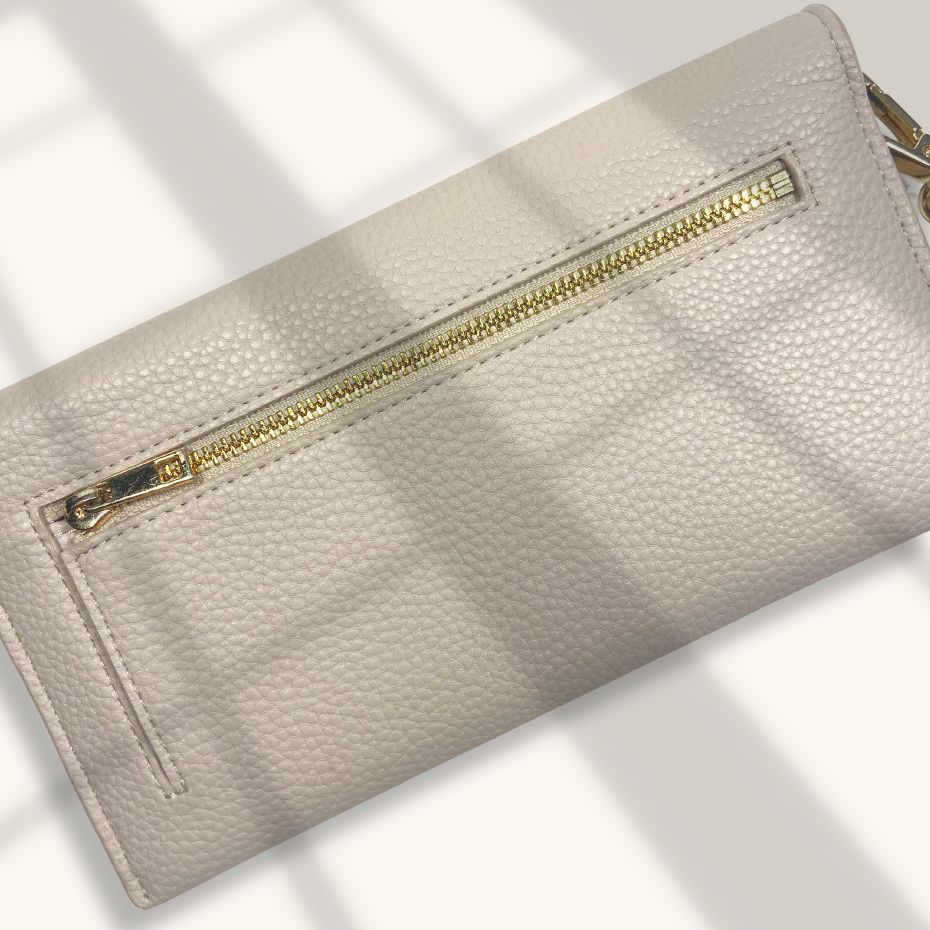 Beige wallet with gold zipper on a light background