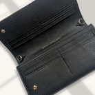 Black leather wallet with gold accents on a light gray background