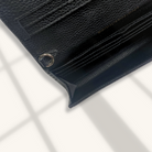 Close-up of a black leather wallet with card slots on a white background