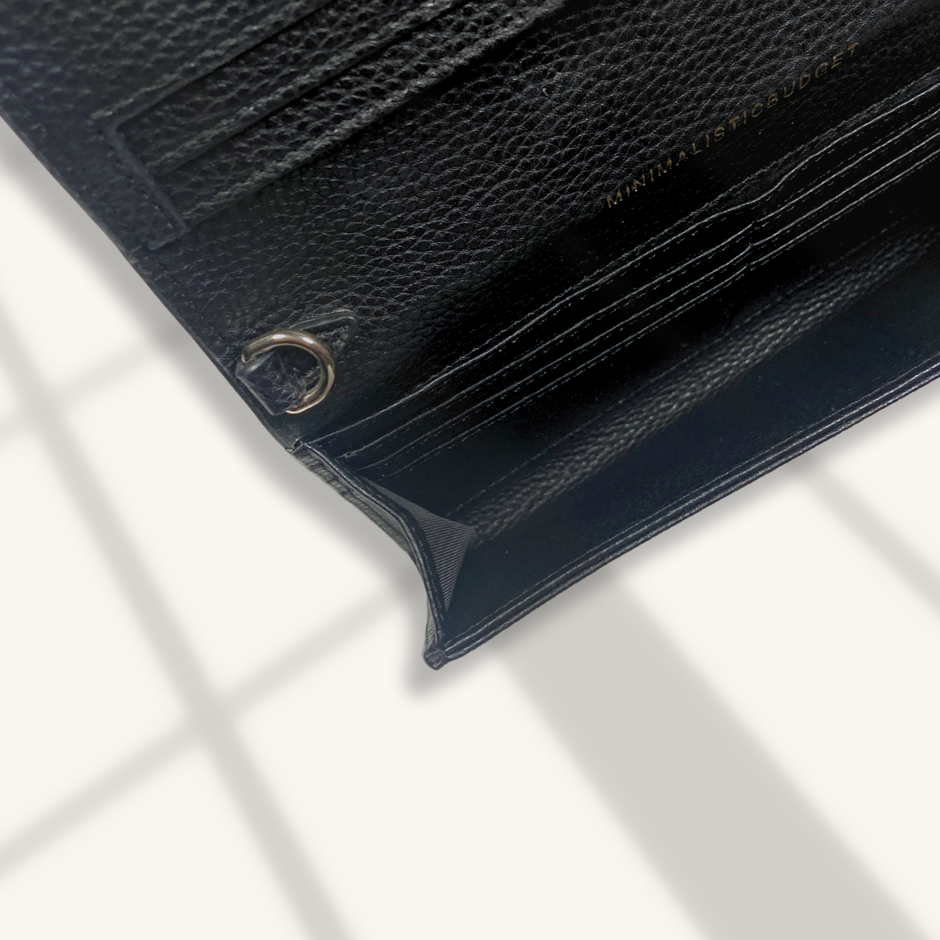 Close-up of a black leather wallet with card slots on a white background