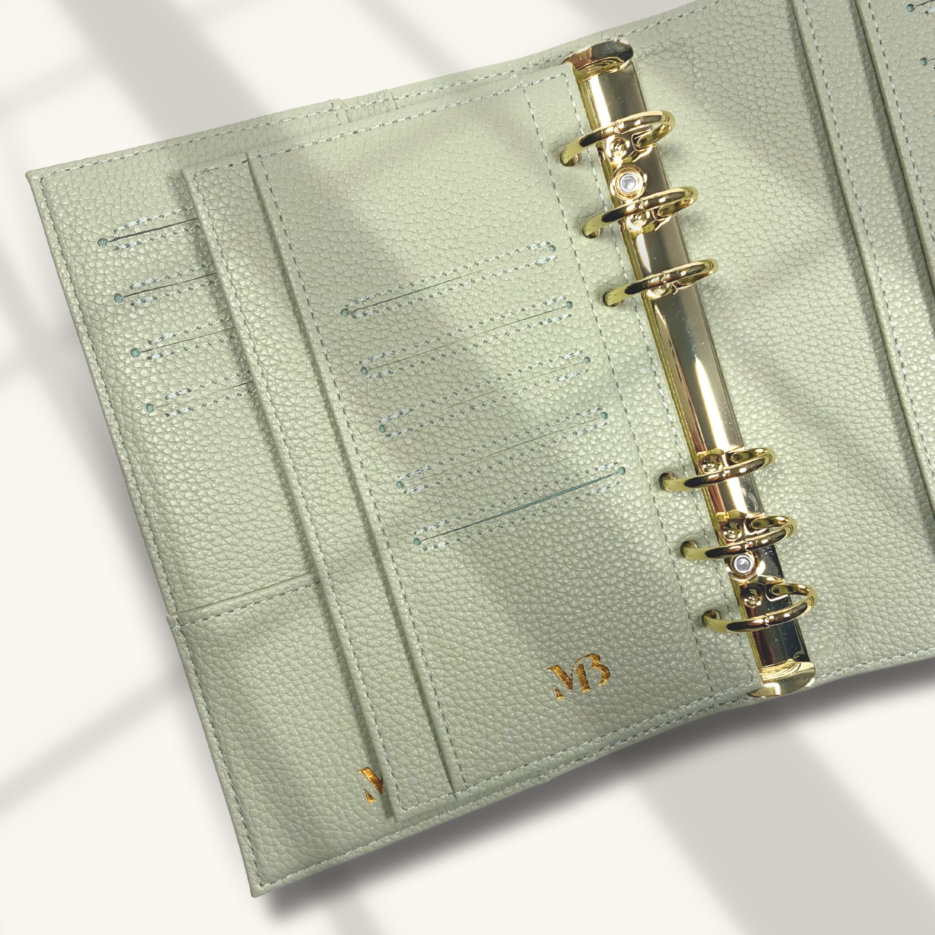 Light green planner with gold binding on a light background