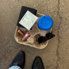 Coffee tray with sunglasses, coffee cup, lipsticks, black wallet, and cash envelopes.